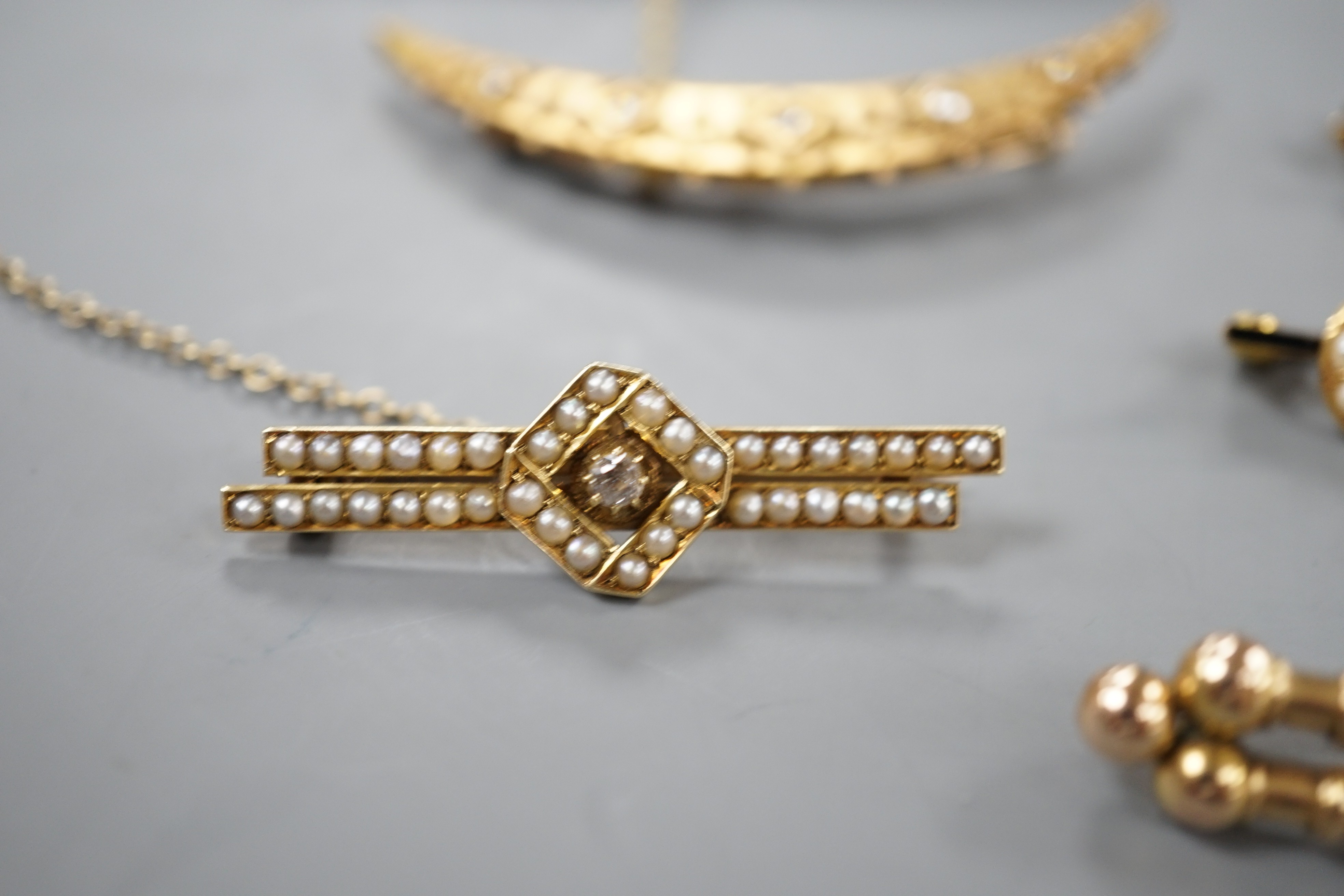 Two assorted late 19th/early 20th century 15ct, diamond and seed pearl set bar brooches including crescent, 53mm and enamel and crescent, gross7 grams, and three other bar brooches, diamond set and seed pearl set, gross
